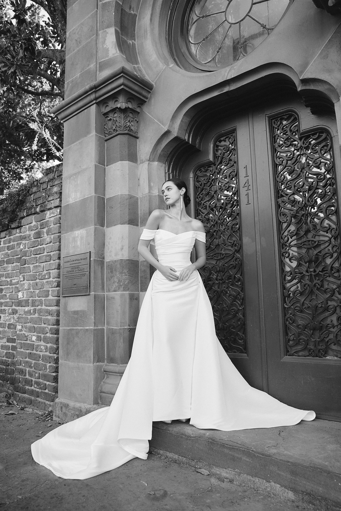 A woman in a white off-the-shoulder gown standing at the Georgetown boutique door