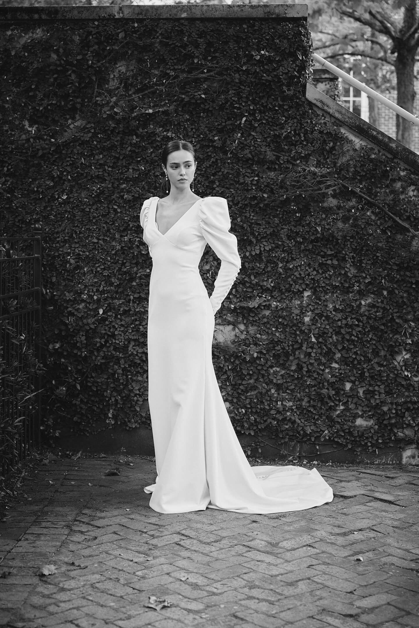 A woman in a long white gown with puffed sleeves